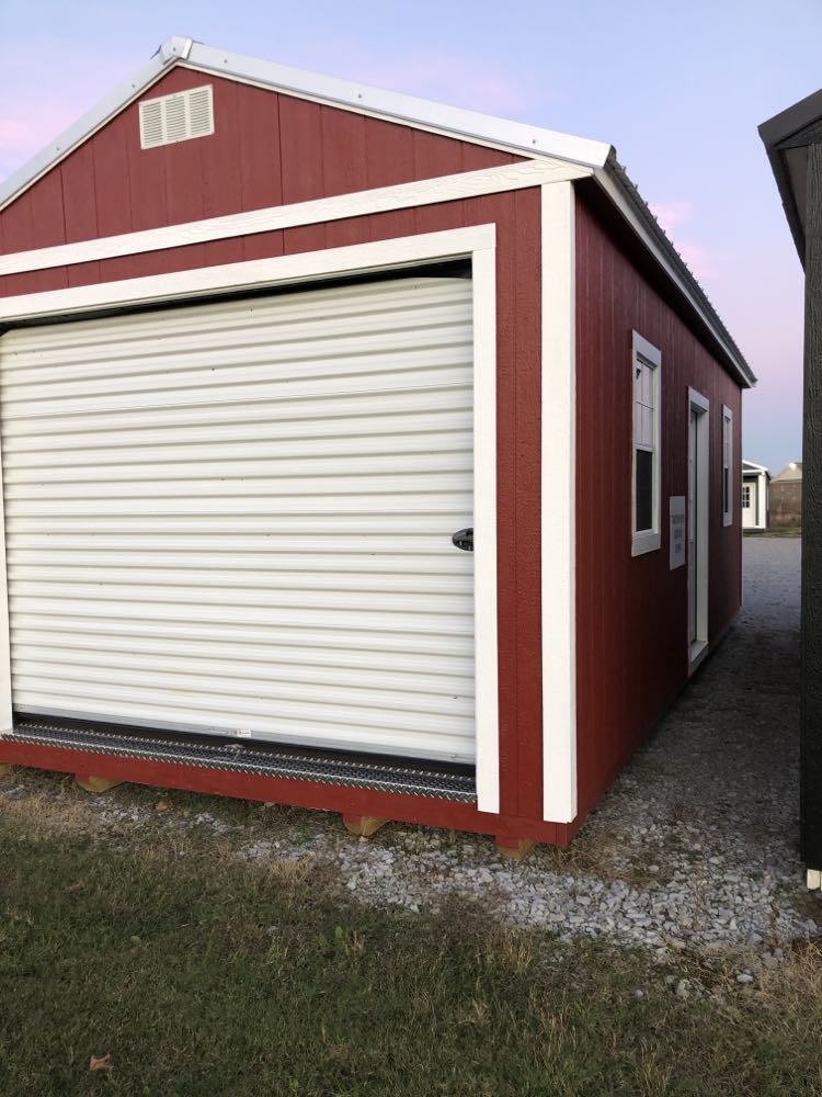 green, large shed with barn doors and white trim 